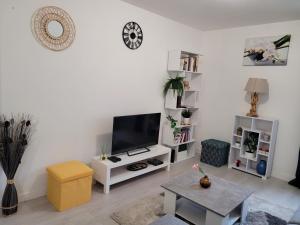 uma sala de estar branca com uma televisão de ecrã plano em Cocooning House 204 Suite Green- Superb studio Aéroport PARIS Roissy CDG, Parc ASTERIX, Château de CHANTILLY, STADE DE FRANCE em Survilliers