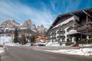 un hotel en las montañas con nieve en el suelo en Hotel Nigritella, en Selva di Cadore