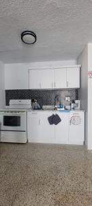 una cocina con armarios blancos y fregadero en Black and white vacation home en Ceiba