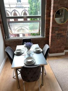a table with plates and a vase of flowers on it at Cornwallis 1 bedroomed 2 beds- sleeps 5- FREE Parking in Liverpool