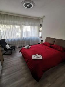1 dormitorio con 1 cama roja y 2 toallas en Terra di Mezzo, en Gorizia