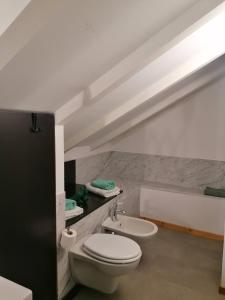 a bathroom with a white toilet and a sink at Arona 01 attic mansarda secondo piano no ascensore in Arona