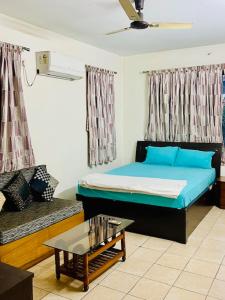 a room with a bed and a couch and a table at Ak22 stays Bardhaman Burdwan in Barddhamān