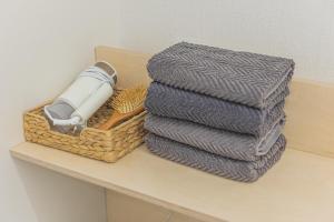 a stack of towels and a basket on a table at KOTARO HOUSE in Seoul