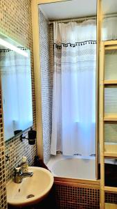 łazienka z zasłoną prysznicową i umywalką w obiekcie Tranquillité w mieście Vincennes