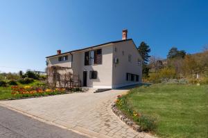 a white house with a driveway and flowers at Villa Tulipa by Briskva in Mošćenice +37 photos