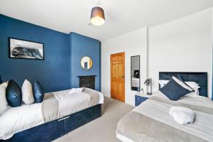 two beds in a room with blue walls at Harbourside Heaven in Bristol - Sleeps 8 in Bristol