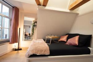 Un dormitorio con una cama y una mesa. en Best Neighbourhood Apartment en Ámsterdam
