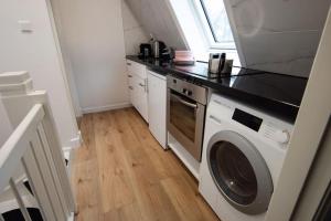 una cocina con lavadora y secadora. en Best Neighbourhood Apartment en Ámsterdam