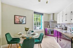 een keuken met een tafel en stoelen en paarse kasten bij Harbourside Heaven in Bristol - Sleeps 8 in Bristol