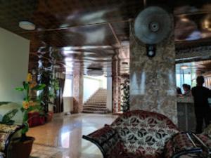 a living room with a couch and a stone wall at Hotel Dev Haweli , Port Blair in Port Blair