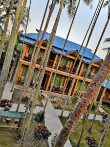 un edificio con palmeras delante en Hotel Dev Haweli , Port Blair, en Port Blair