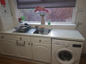 a kitchen with a sink and a washing machine at Long Stay, Contractors, Stags & Hens in Elswick