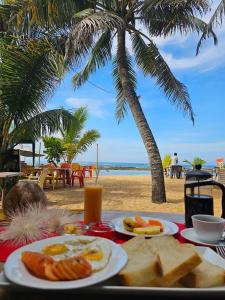 Paradise Garden Beruwala في بيرووالا: طاولة مع أطباق من الطعام على الشاطئ