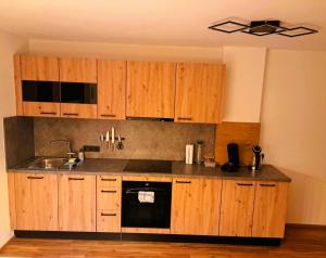a kitchen with wooden cabinets and a sink at Apart Sunny Side in Ramsau im Zillertal