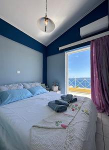 a bedroom with a large bed with a large window at Summer Villa , Kaki Thalassa in Dhaskalión