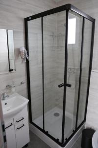 prysznic ze szklanymi drzwiami obok umywalki w obiekcie Rezort pod Roháčmi w Witanowej
