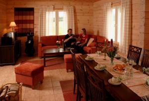 un homme et une femme assis dans un salon dans l'établissement Hostel Lomakivi, à Kausala