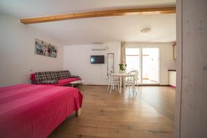 Televízia a/alebo spoločenská miestnosť v ubytovaní Villa Carmen Rooms & Apartments