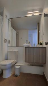 uma casa de banho com um WC e um espelho grande em Depto cercano a playa El Faro La Serena em La Serena