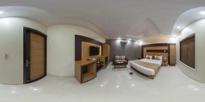a large room with a bed and a television at Hotel Pushkar City Inn in Pushkar