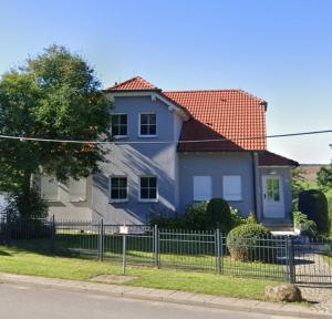 a blue house with a fence in front of it at Idyllische Lage im Süden Erfurts in Erfurt