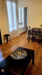 un soggiorno con tavolo e ciotola di Tranquillité a Vincennes