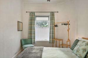 sypialnia z łóżkiem, krzesłem i oknem w obiekcie Finest Retreats - Atherfield Apartments No 6 - Tree Tops w mieście Paignton