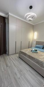 a bedroom with a large bed and a room with at Красивая квартира ЖК Алматым in Almaty