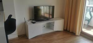 a tv sitting on a white dresser in a room at Tinas Ruhepol mit Terrasse und Meerblick in Kableshkovo