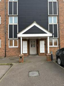 a brick house with two white garage doors at Lakeside apartment with FREE parking / M25 in Purfleet