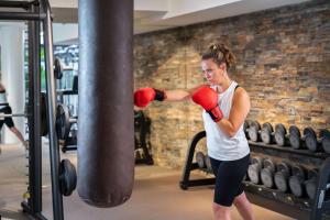 a woman in a gym with a pair of boxing gloves at art'otel Rome Piazza Sallustio, Powered by Radisson Hotels in Rome