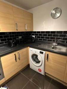 a kitchen with a washing machine and a sink at Lakeside apartment with FREE parking / M25 in Purfleet