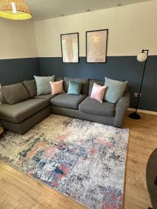 a living room with a couch and a rug at Lakeside apartment with FREE parking / M25 in Purfleet