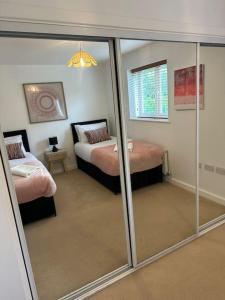 a bedroom with two beds and a mirror at Lakeside apartment with FREE parking / M25 in Purfleet