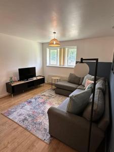 a living room with a couch and a tv at Lakeside apartment with FREE parking / M25 in Purfleet