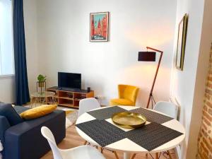 Capitole, Grand T1 bis, lumineux, neuf. في تولوز: غرفة معيشة مع طاولة وأريكة زرقاء