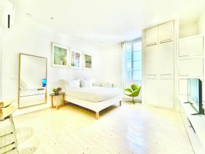 - une chambre blanche avec un lit et un canapé dans l'établissement Èrsextius ABB Aix-en-Provence, à Aix-en-Provence