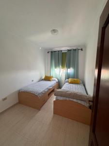 2 Betten in einem kleinen Zimmer mit ermottermott in der Unterkunft Vivienda vacacional Lomada in San Isidro