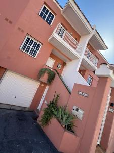 ein rosafarbenes Gebäude mit Pflanzen davor in der Unterkunft Vivienda vacacional Lomada in San Isidro