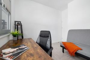 ein Wohnzimmer mit einem Holztisch und einem Bett in der Unterkunft Złota Apartment with Balcony & Parking Near Zoo Katowice by Renters in Kattowitz