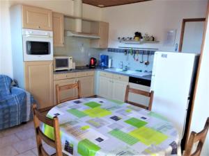 eine Küche mit einem Tisch und einem weißen Kühlschrank in der Unterkunft Gite 4 Vent « Vent du Nord » in Audinghen