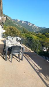 una mesa y sillas en un balcón con una montaña en Le Maricou 120m2 totalement rénové terrasse 40m2, en Châtillon-en-Diois