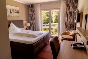 a hotel room with a bed and a window at Forsthaus Seebergen in Lütjensee +36 photos