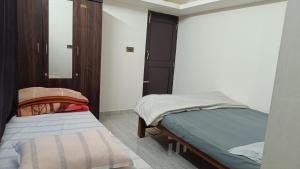 a bedroom with two beds and a mirror at Thotadagadde Home stay in Mudigere