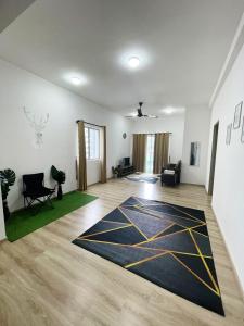 uma sala de estar com um tapete preto e amarelo no chão em Aira Muslim's Homestay em Tanah Rata