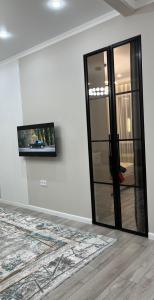 a room with a mirror and a tv on a wall at Красивая квартира ЖК Алматым in Almaty