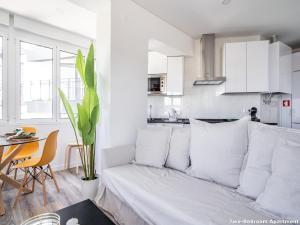 a white living room with a couch and a table at Akicity Campolide Sun in Lisbon