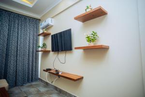 Pokój z drewnianymi półkami na ścianie w obiekcie Ridge Estates w mieście Dar es Salaam