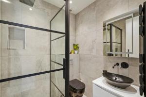La salle de bains est pourvue d'un lavabo et d'une douche. dans l'établissement Grand Flat in Little Venice - Sleeps 8, à Londres